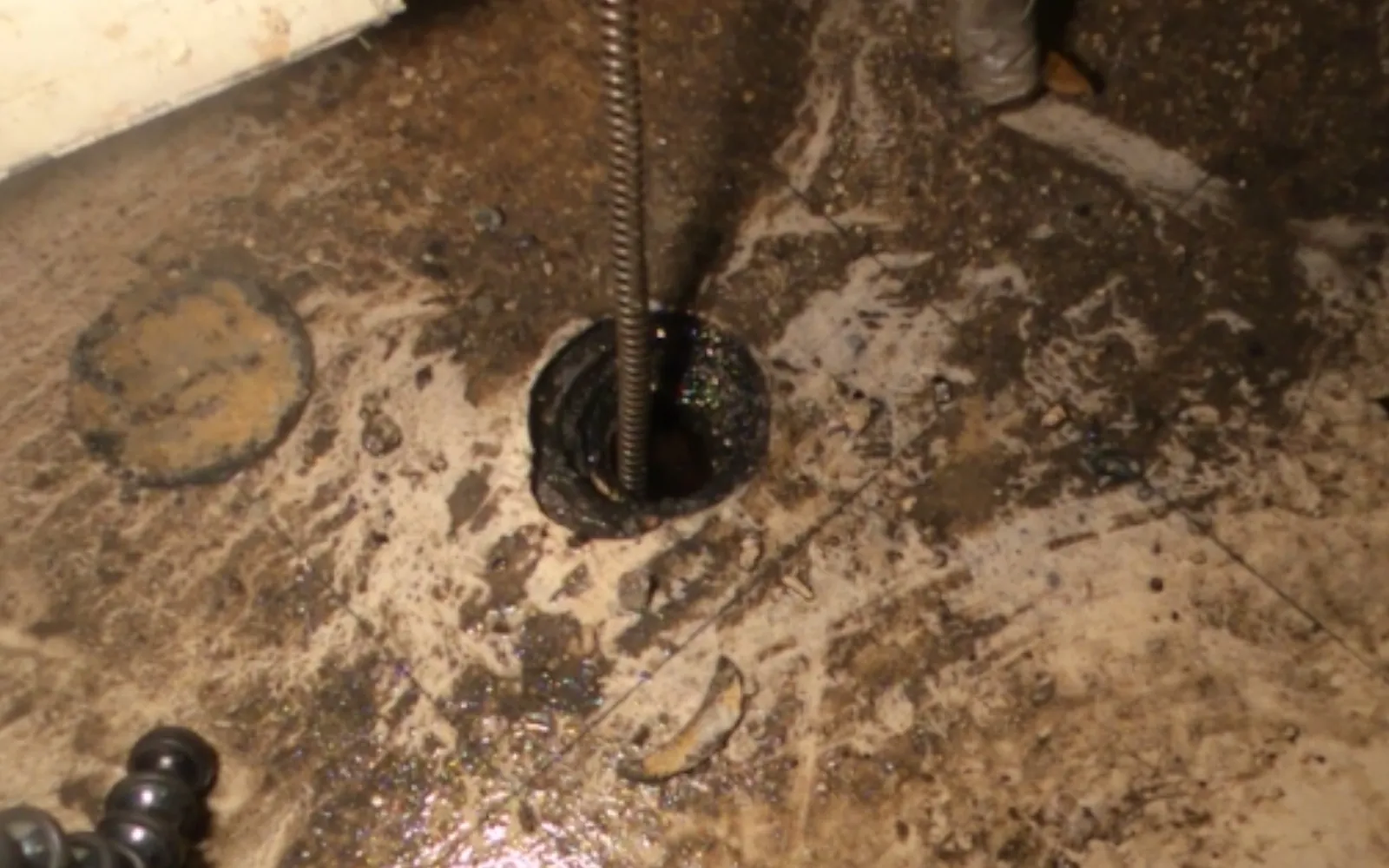 drain cable being fed into an outdoor sewer cleanout