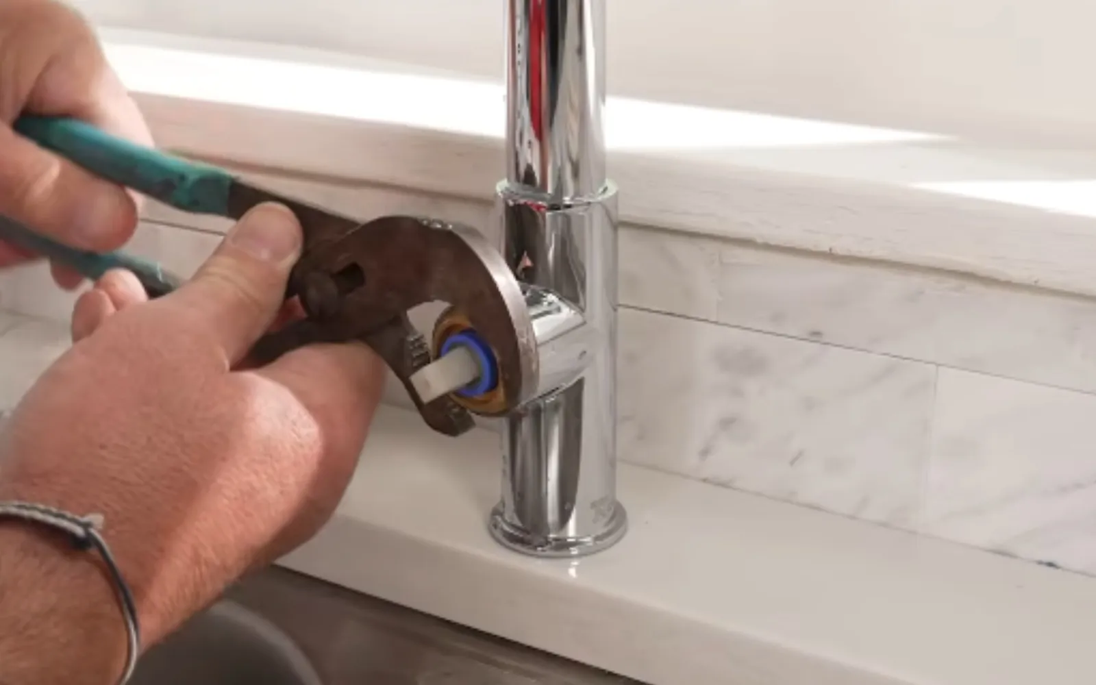 hands replacing a kitchen faucet cartridge