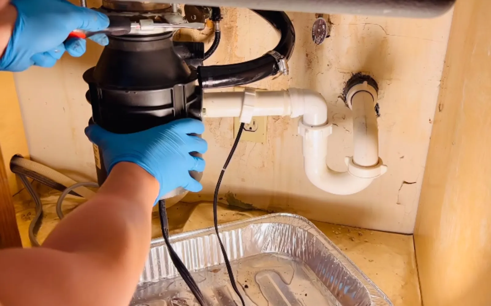 garbage disposal unit under a kitchen sink