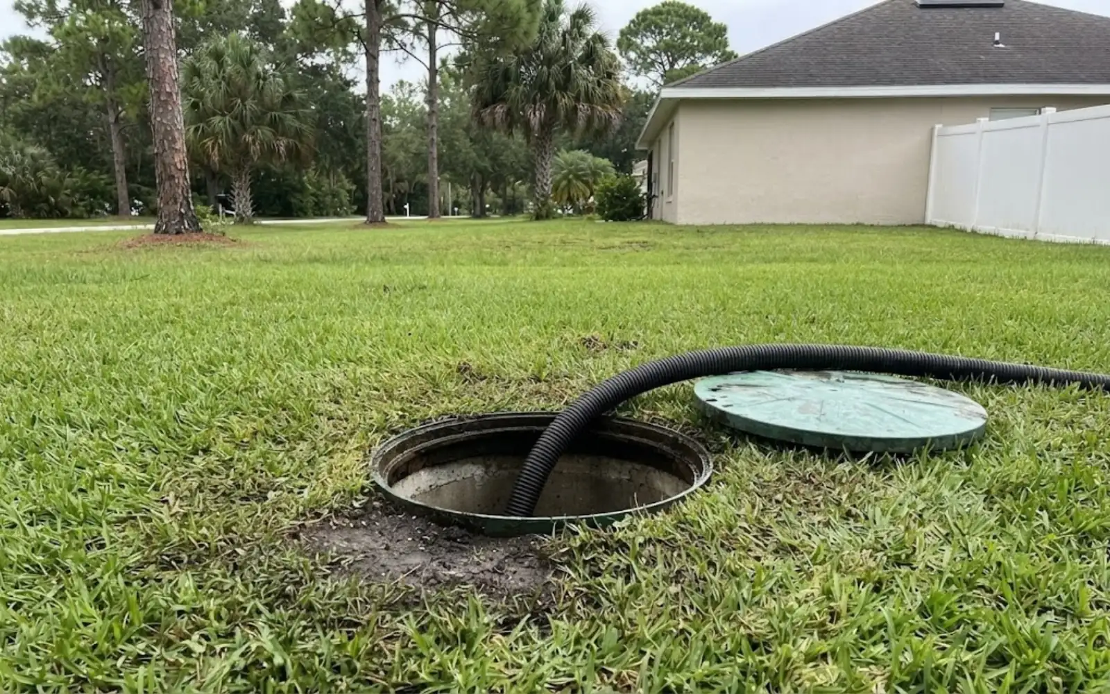 septic tank lid open in a lawn during pumping