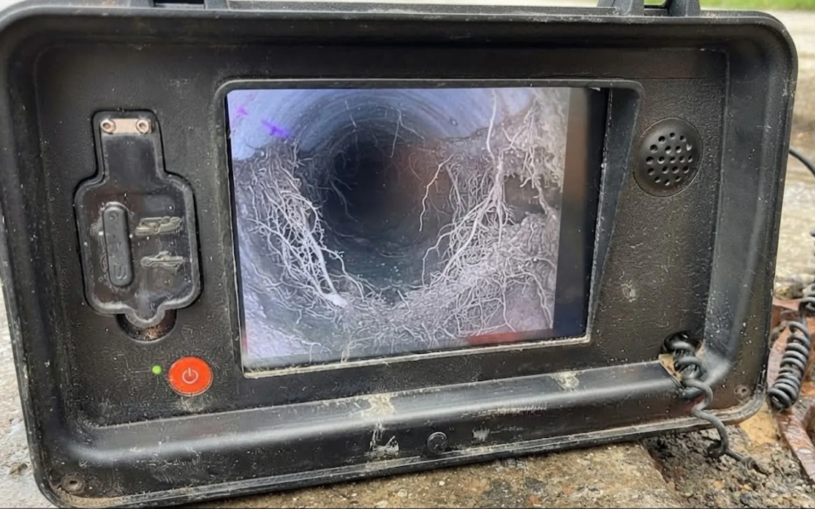 sewer camera monitor showing tree roots inside a pipe joint