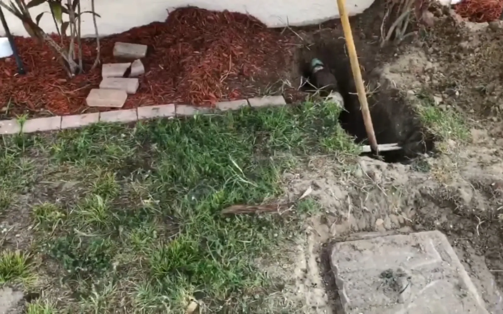 excavated clay sewer pipe with a cracked joint being repaired