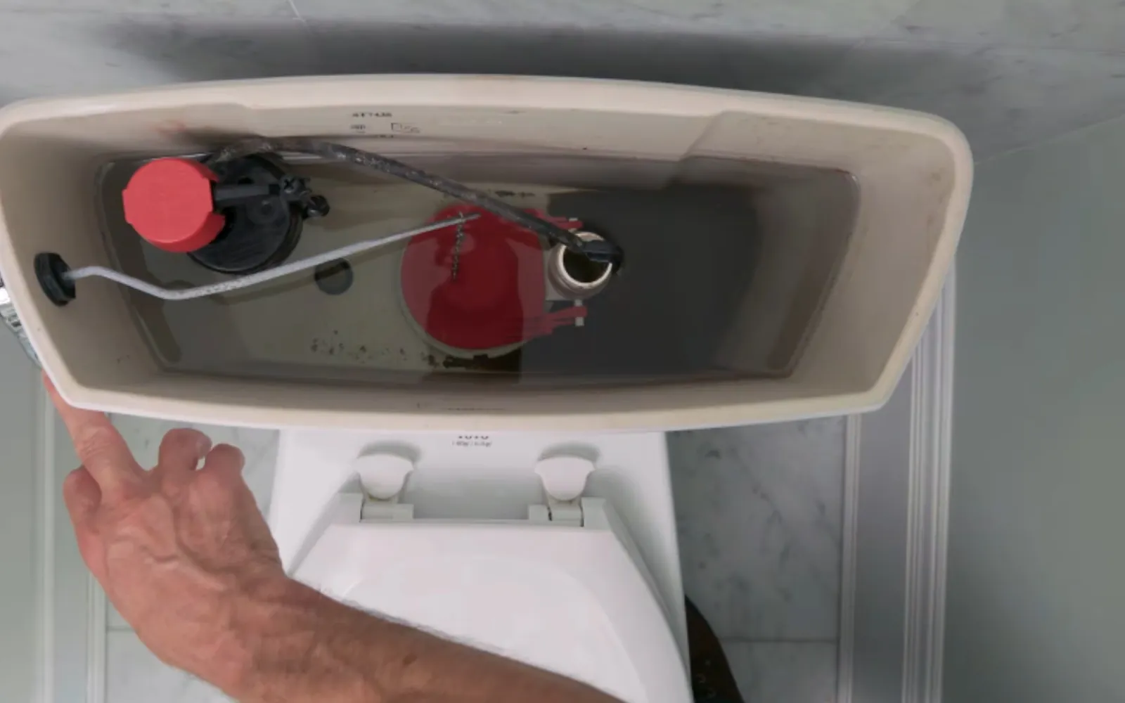 plumber replacing a toilet flapper inside the tank
