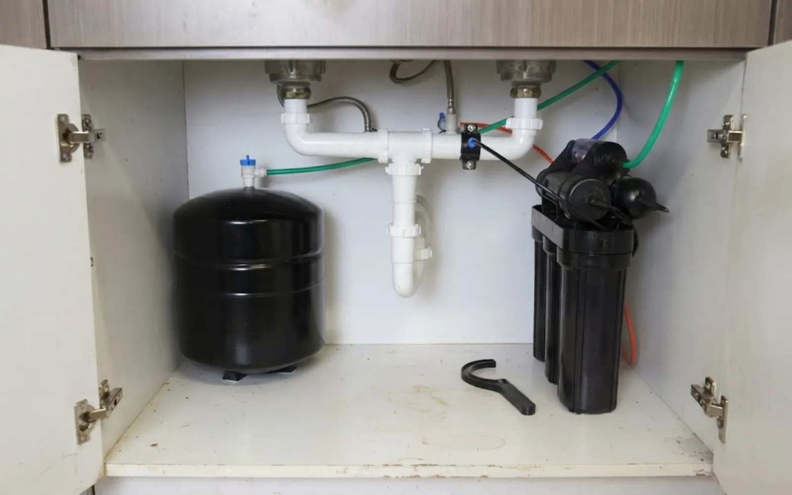 whole house water filter housings mounted on a garage wall